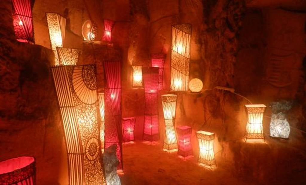 Dekorative, leuchtende Laternen in verschiedenen Formen und Größen tauchen eine Höhle in Valkenburg in warmes Licht.
