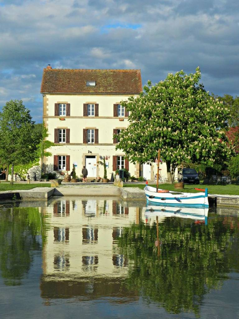 Chambre d'hôtes in Burgundy overlooking the canal with a boat and blossoming chestnut tree