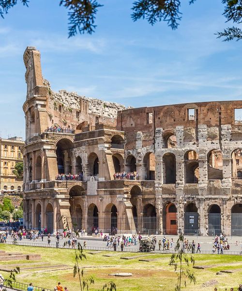 An extremely large circular-shaped structure of ancient ruins with many people walking around the outside of it