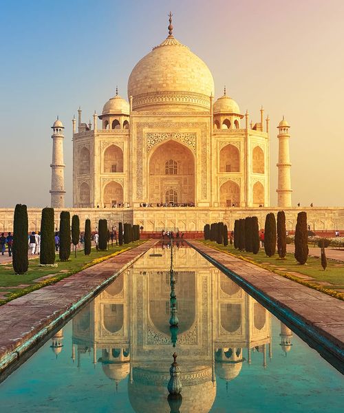 An extremely large white ornately decorated building with a reflection pool in front of it