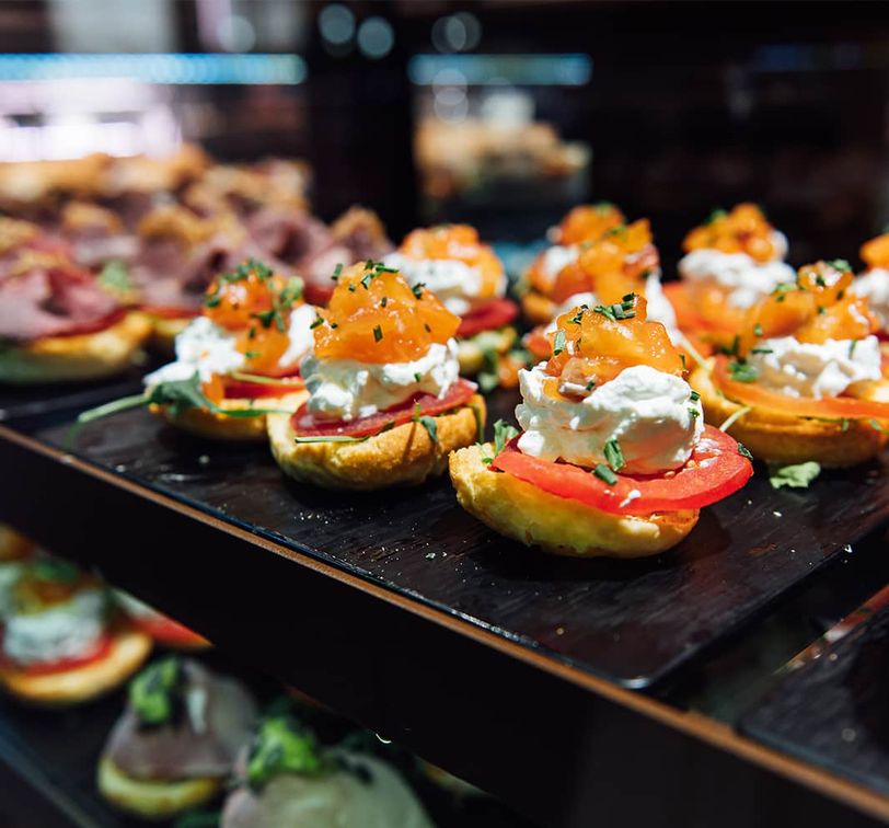 A display case full of small open-faced sandwiches