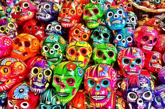 A large pile of various brightly colored skulls