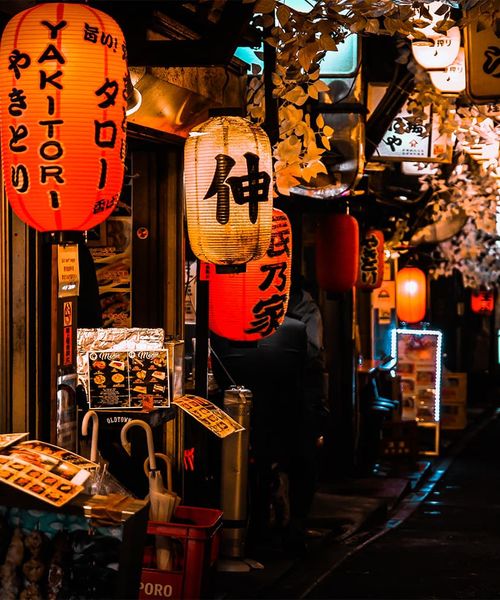 A storefront with several red and white lit up lanterns during nighttime