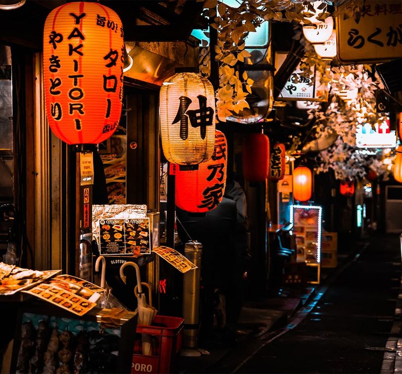 A storefront with several red and white lit up lanterns during nighttime