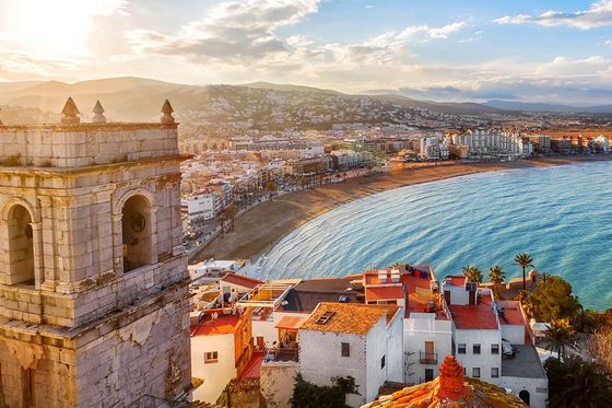 Aerial view of a coastal city with white buildings and red roofs