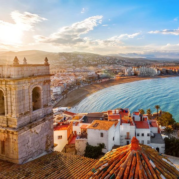 Aerial view of a coastal city with white buildings and red roofs