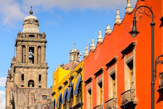 A row of colorful buildings leading to a stone church