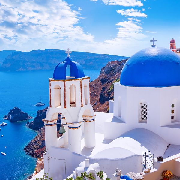 Sunny day in Santorini with close-up view of blue and white domed buildings