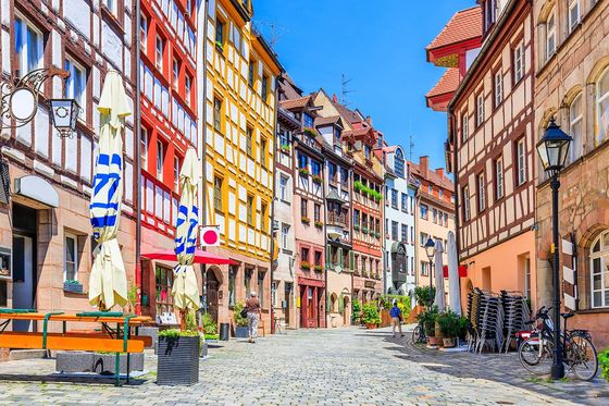 A cobblestone street of buildings lined with colorful timber