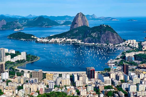 An aerial view of a large city situated next to the shore with many islands scattering the sea