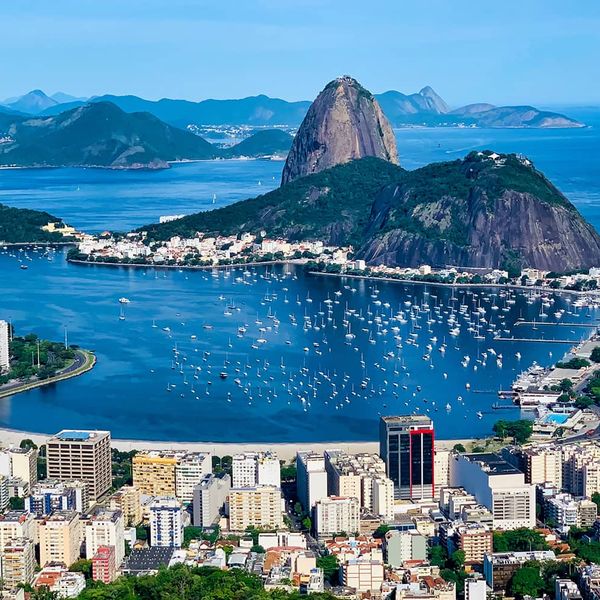 An aerial view of a large city situated next to the shore with many islands scattering the sea