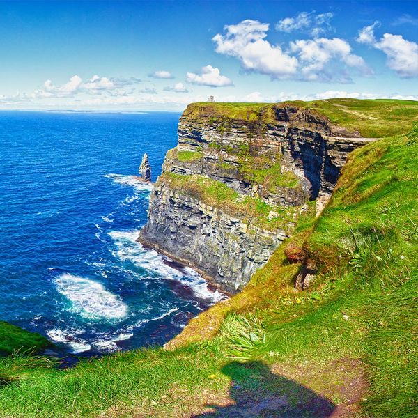 A sharp grass-covered cliff at the edge of the sea