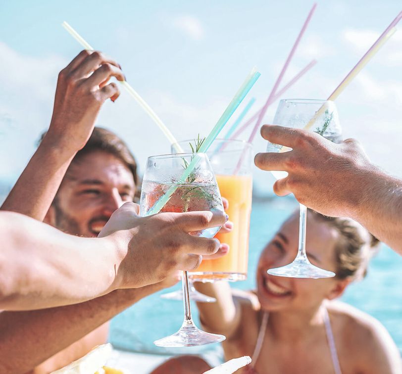 Four young people on a boat toasting with drinks
