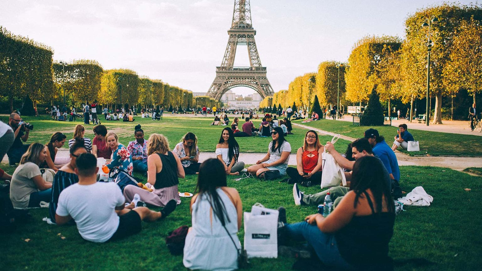 A group of people having a picnic in front of the Eiffel Tower in Paris.
