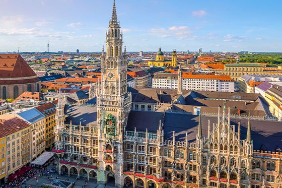 An aerial view of a large city with extremely ornate and detailed buildings with many people walking the streets