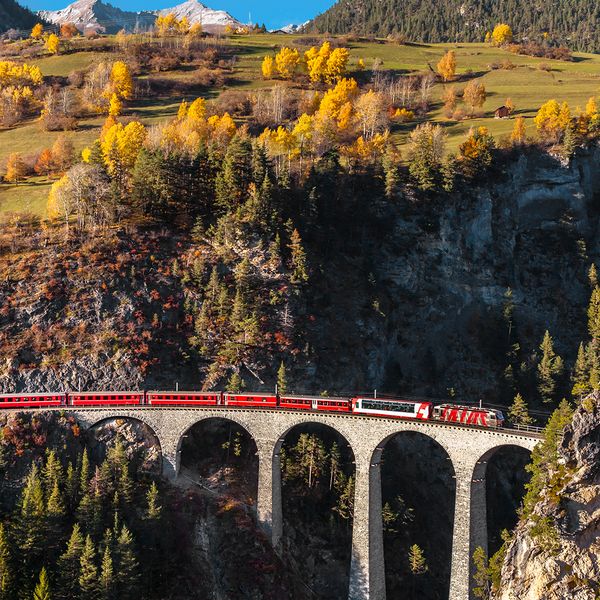 train crossing bridge in the swiss alps