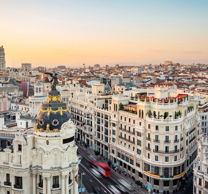 sunset over landmark buildings on gran via street in madrid spain