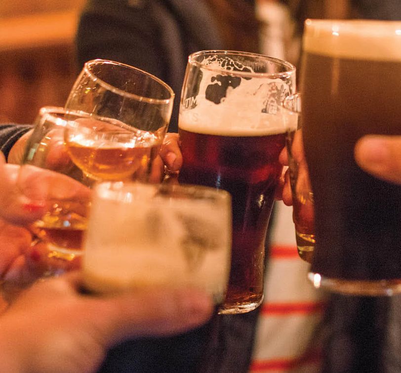 close up of people cheering their glasses of beer