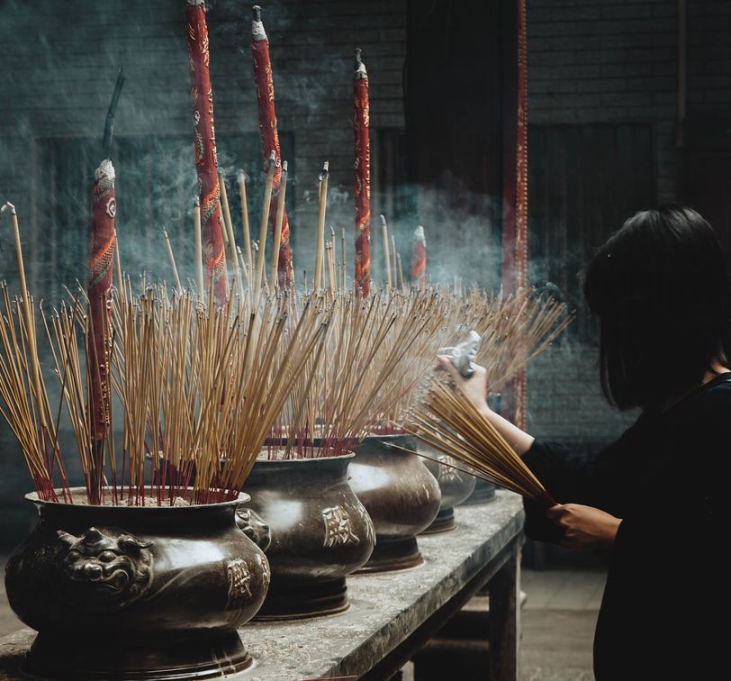 woman lighting incense at a temple in ho chi minh city vietnam