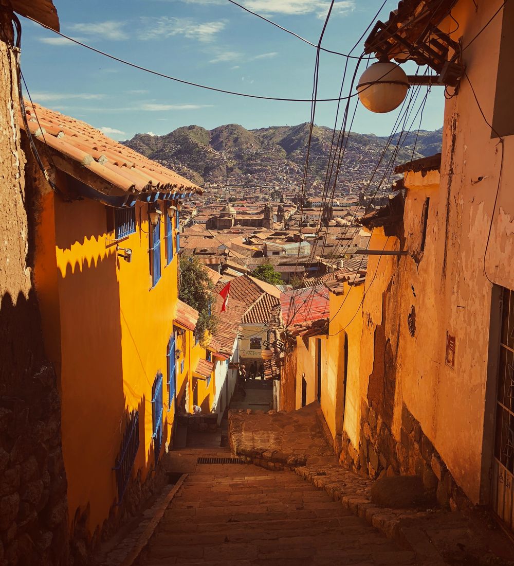 yellow houses on a cobblestone street in cuzco peru