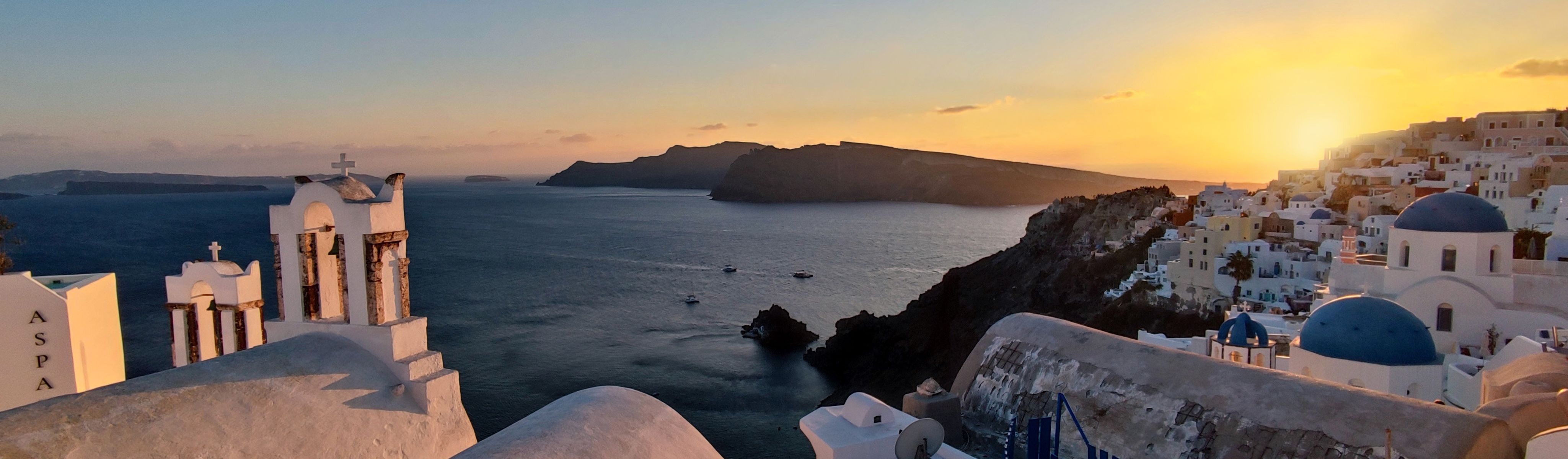 blue domed buildings in greece at sunset