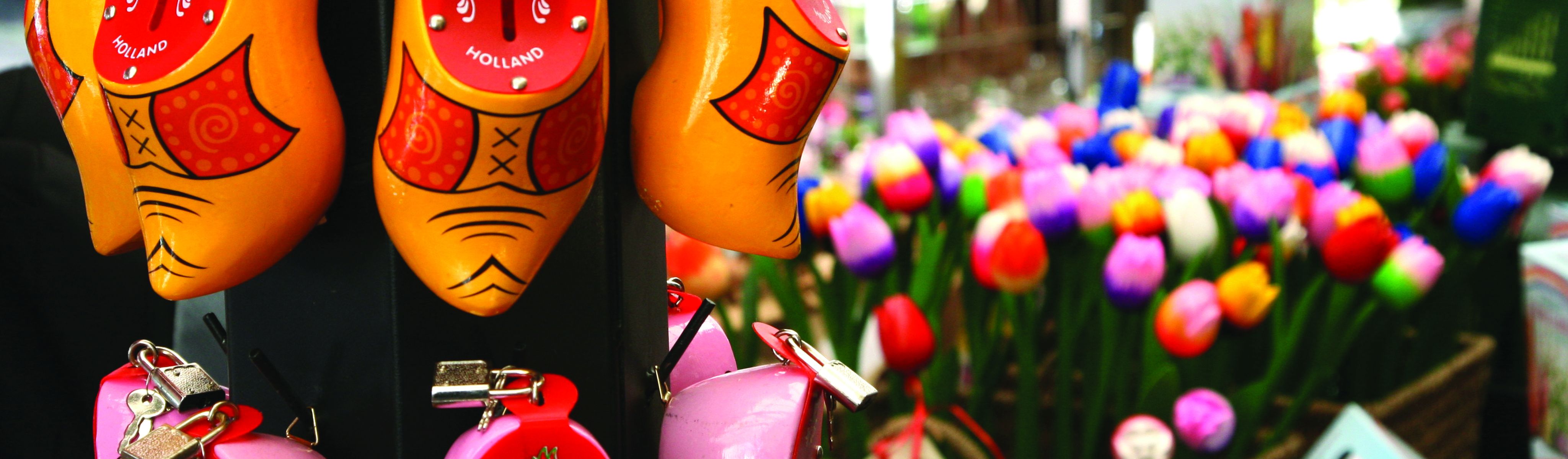 yellow and red wooden clogs hanging outside a market