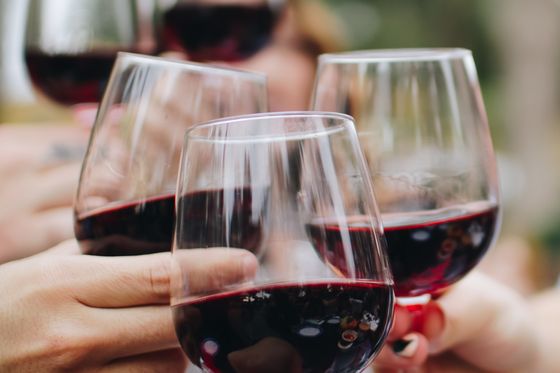 several wine glasses filled with red wine