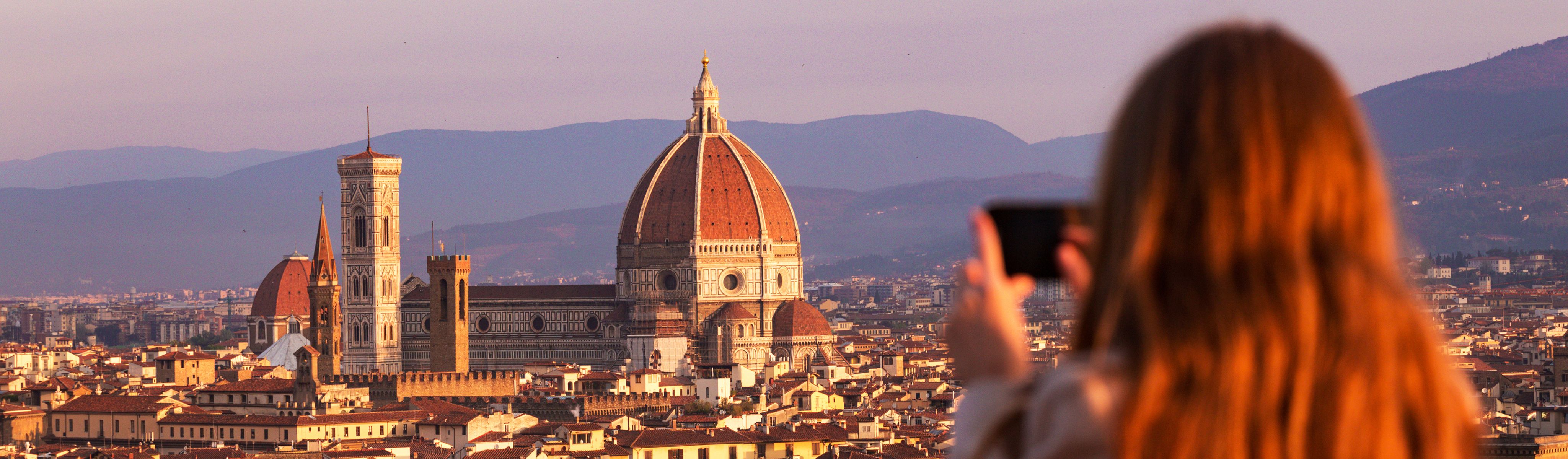 woman taking a photo of the duomo in florence, italy