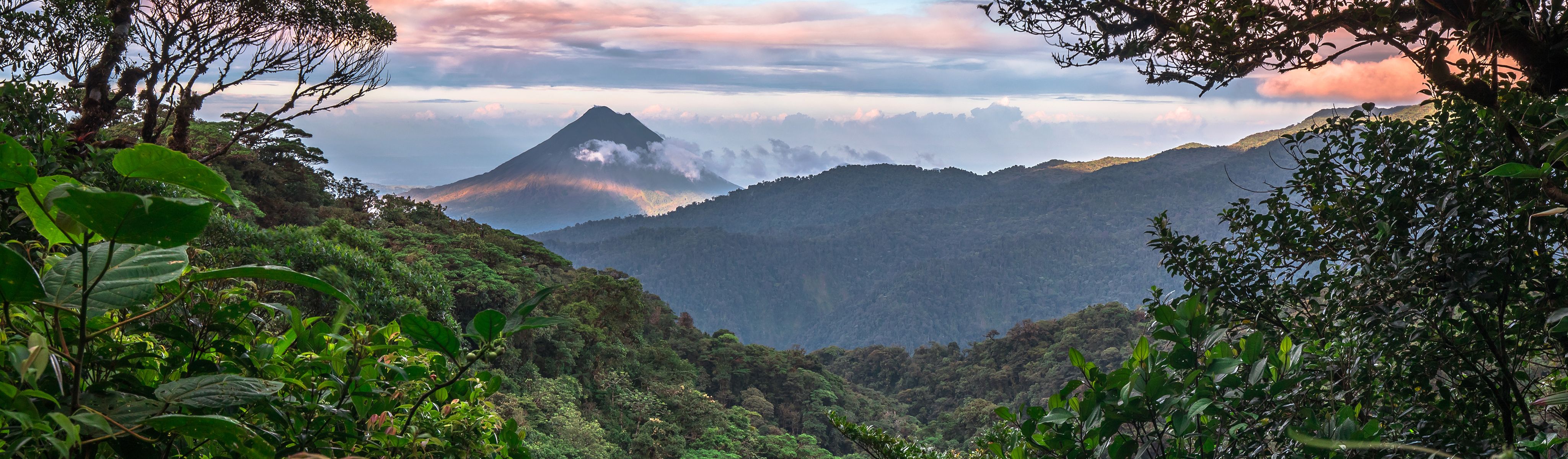 arenal volcano in monteverde costa rica surrounded by clouds at sunrise