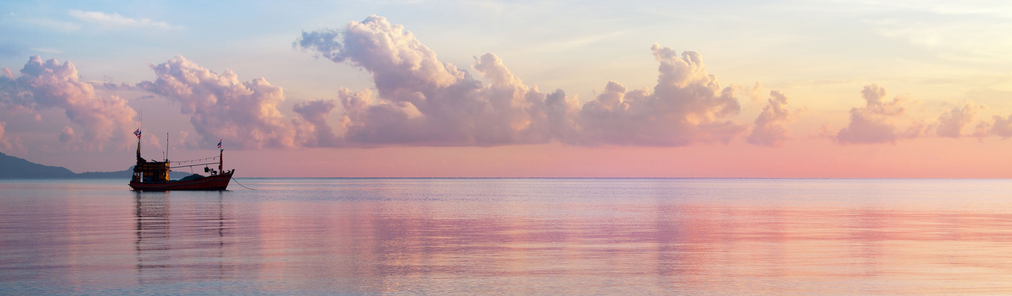 boat floating in the gulf of thailand at sunset