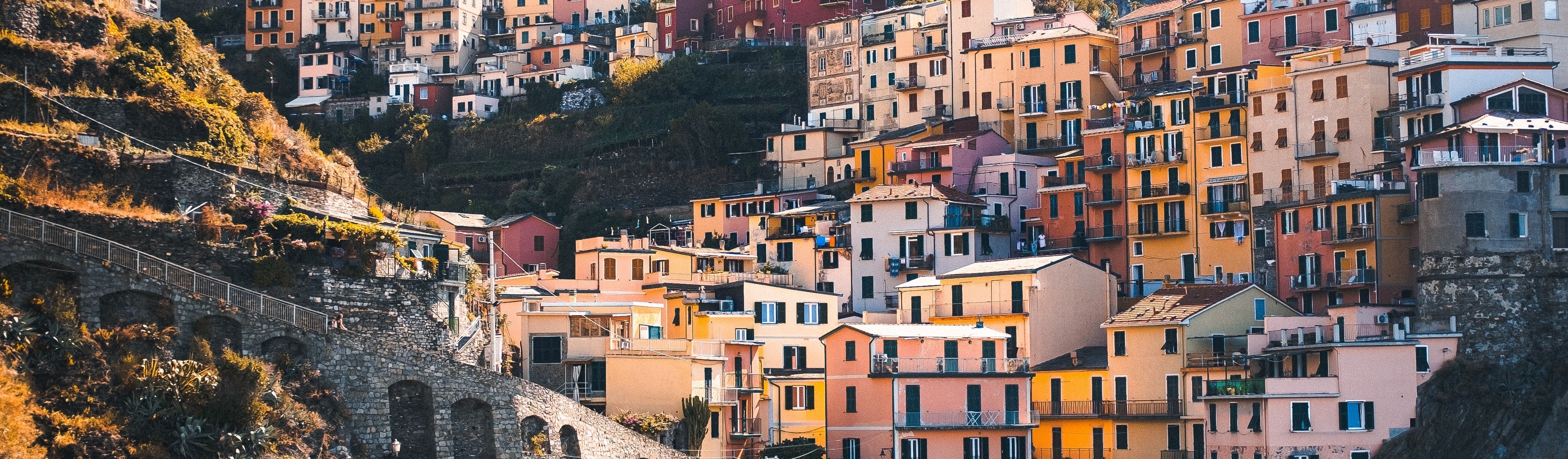 yellow and orange pastel houses along the coast in cinque terre italy