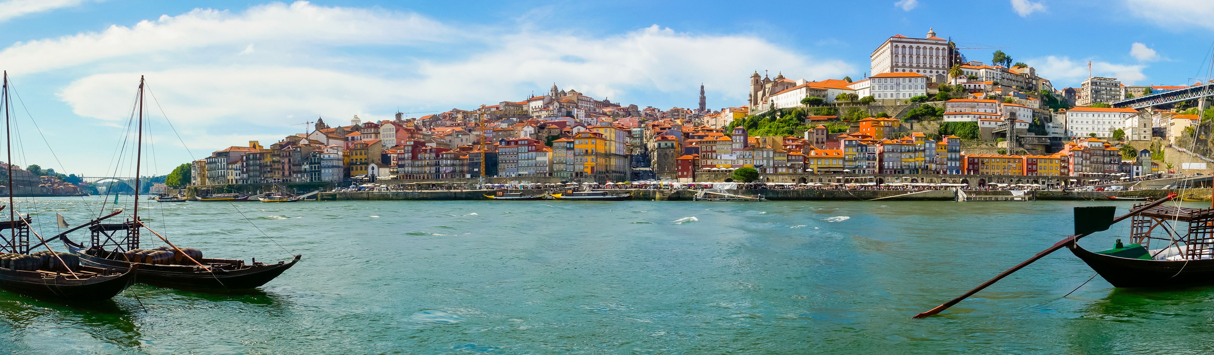 boats docked in front of colorful buildings along the douro river in porto portugal