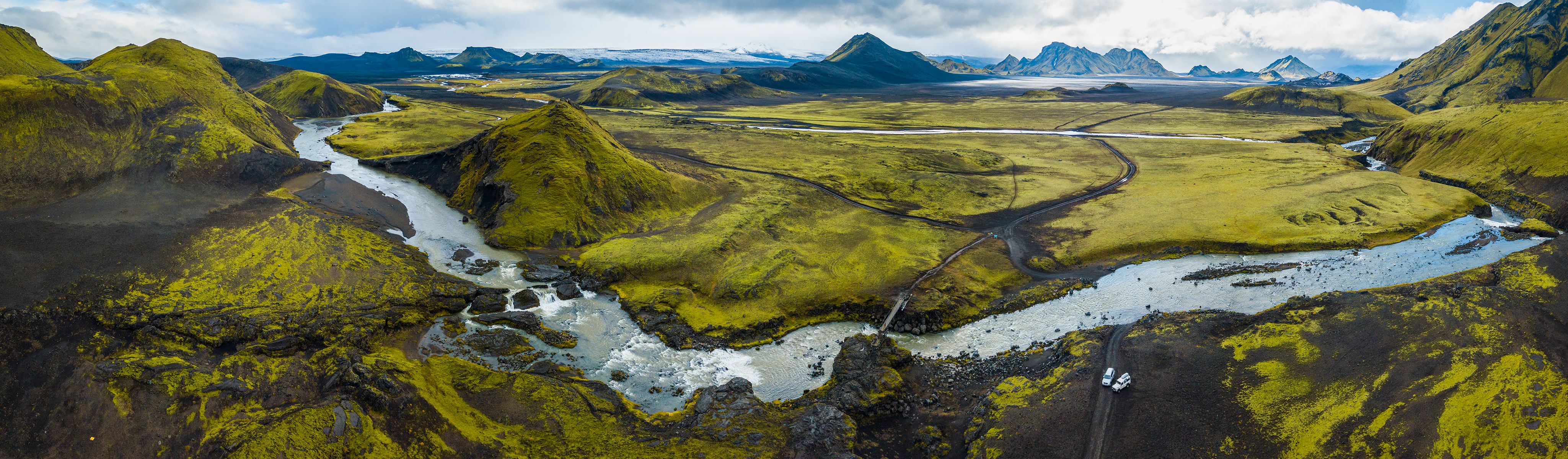 river running through a lush green valley in iceland