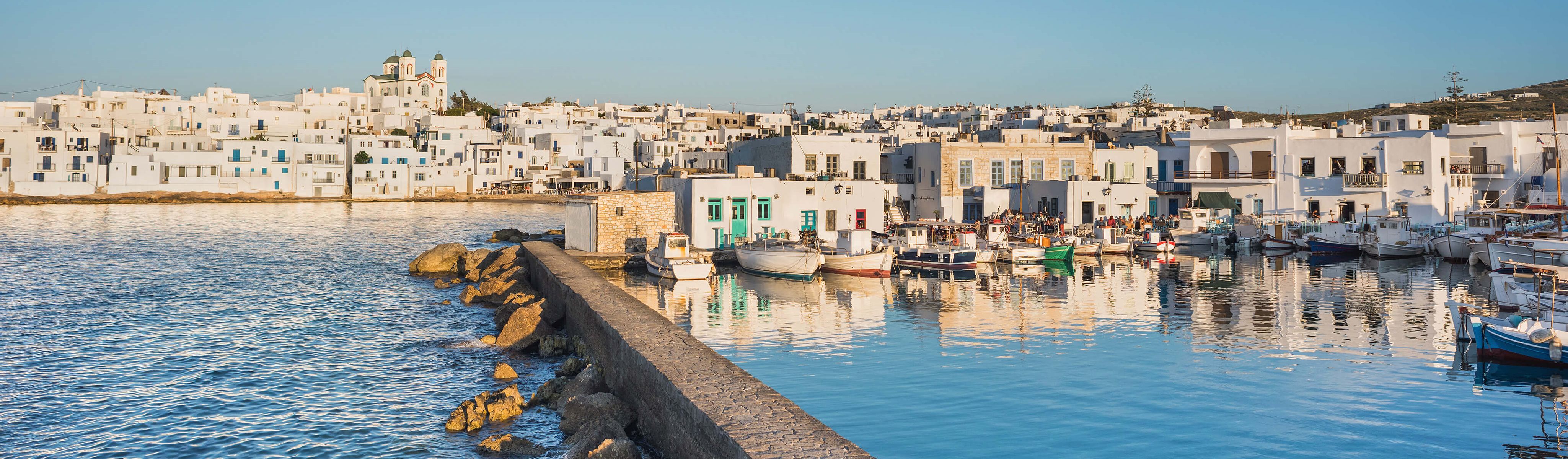 boats lining the marina shoreline in paros greece