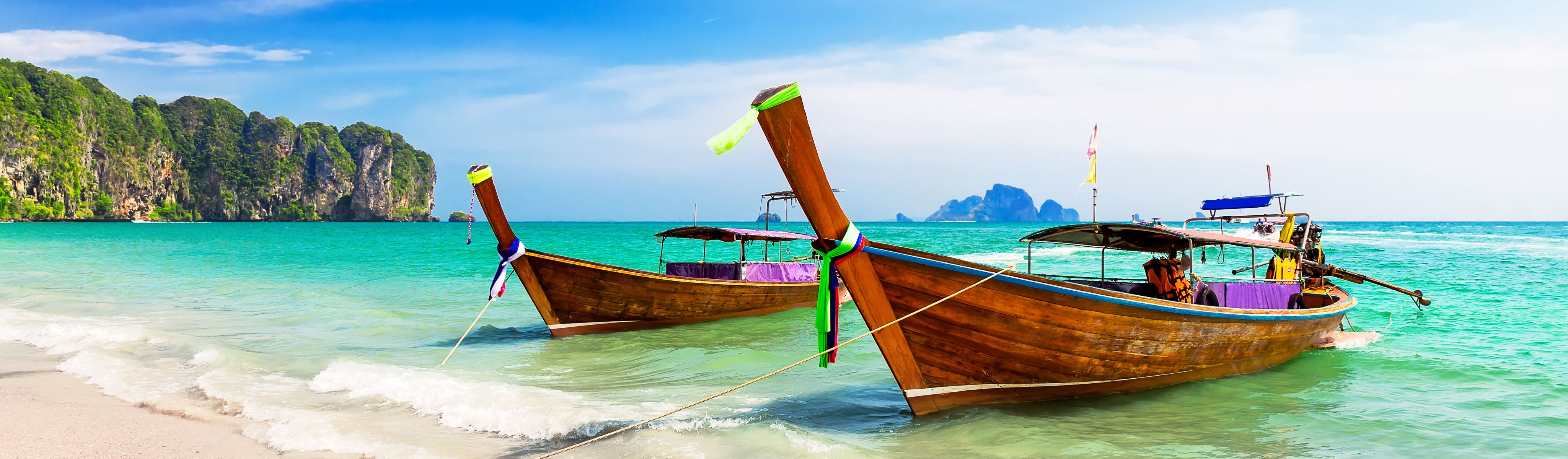 wooden boats docked on the beach off of the phi phi island