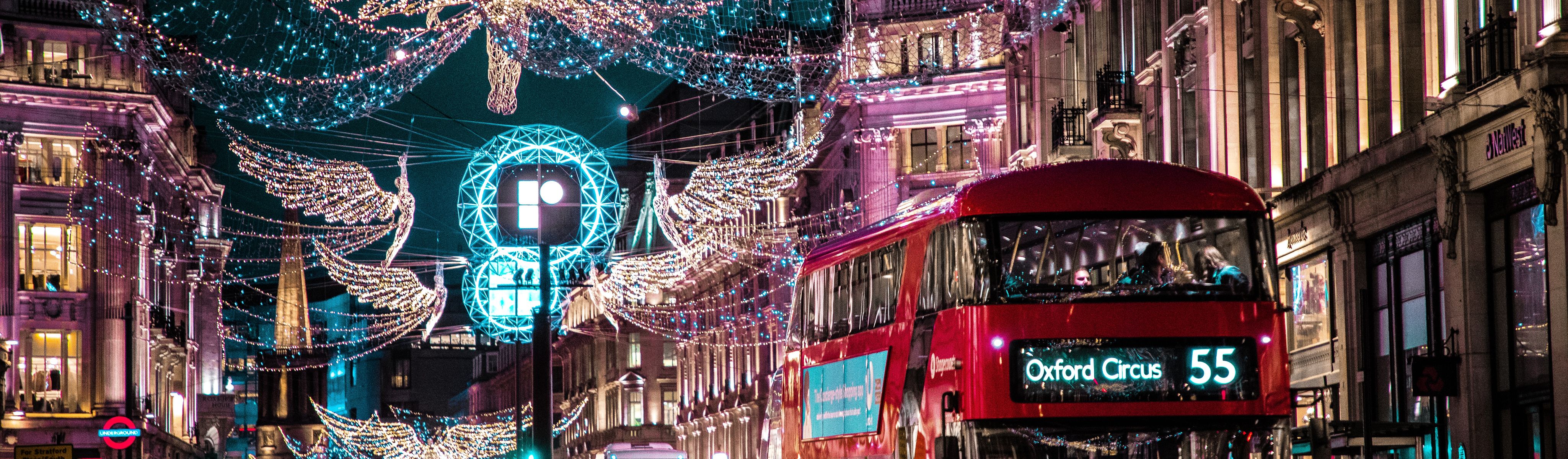 double decker bus riding through streets of london during christmas