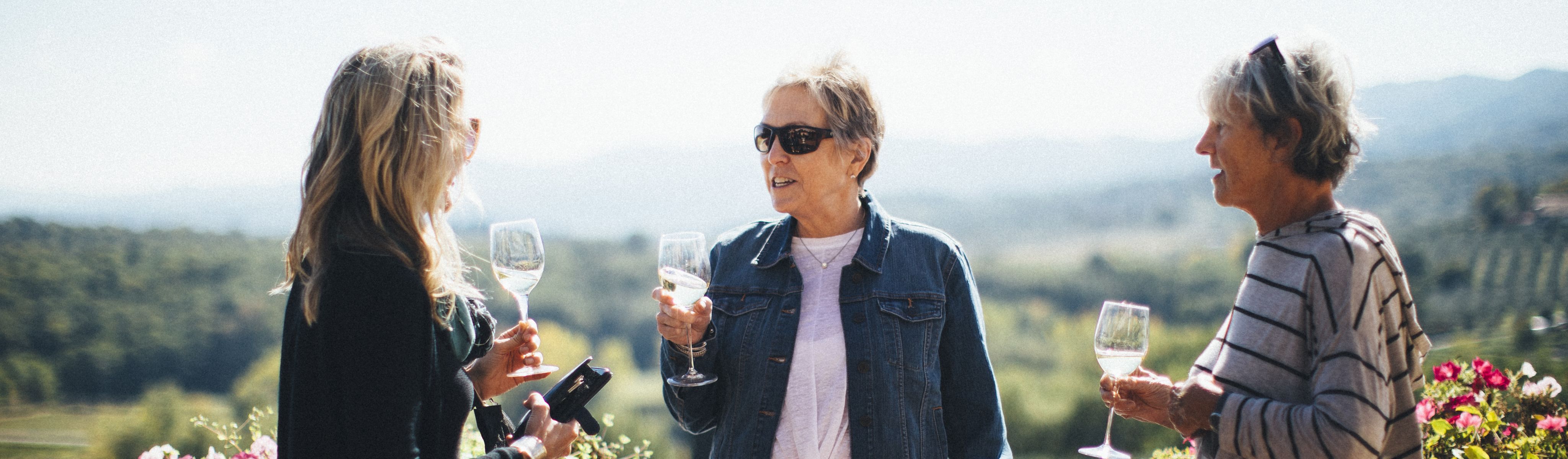 three ladies cheering white wine in tuscany