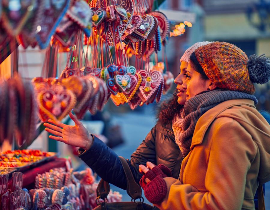 women looking at christmas ornaments at an outdoor market