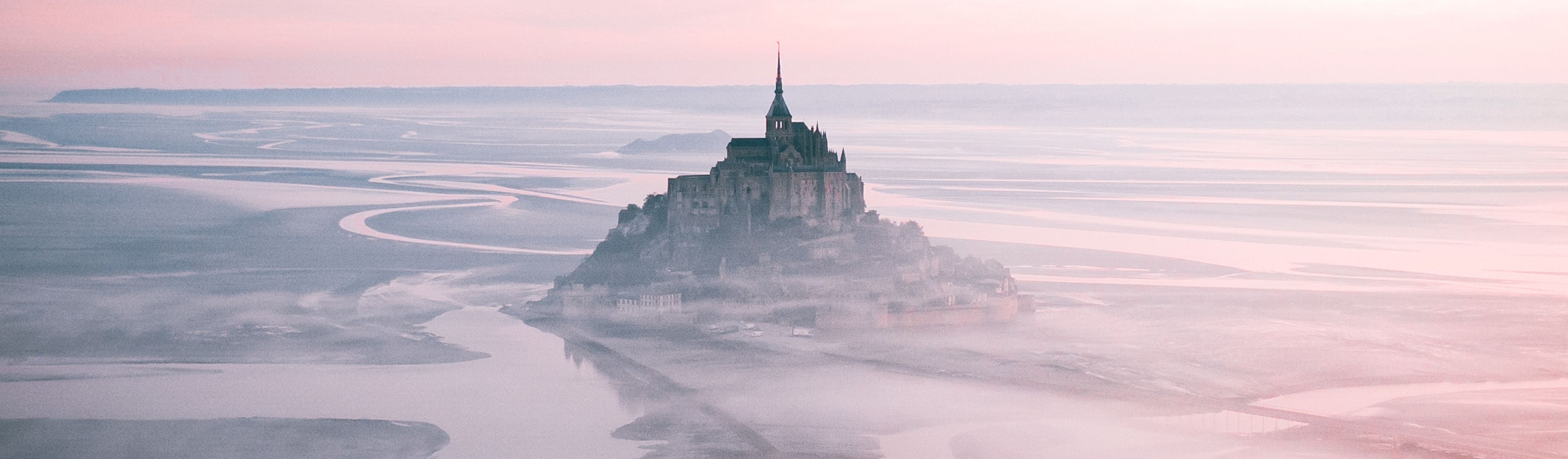 Mont Saint-Michel surrounded by fog at dusk in france