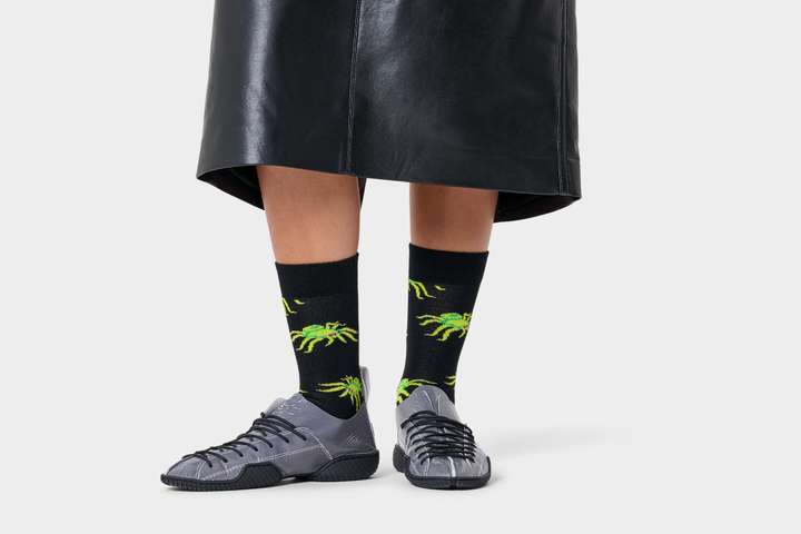 A black background filled with graphical halloween objects and colourful happy socks. 