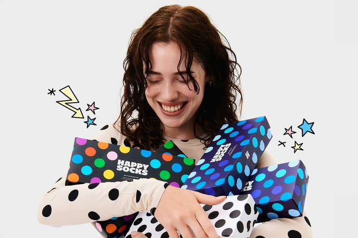 A person carrying a heap of Happy Socks Dots Gift Sets