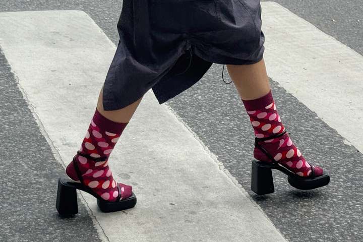 Zwei Paar Beine auf grauem Untergrund, mit Punkten und Ringelsocken