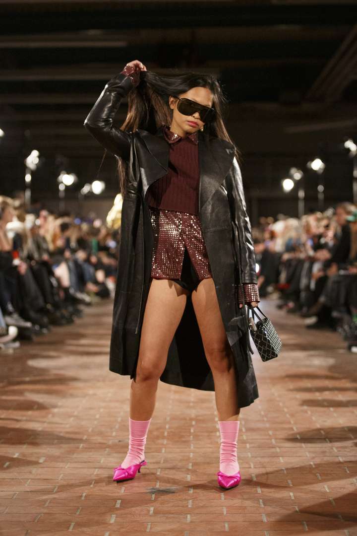 A person walking on the runway, wearing pink happy socks.