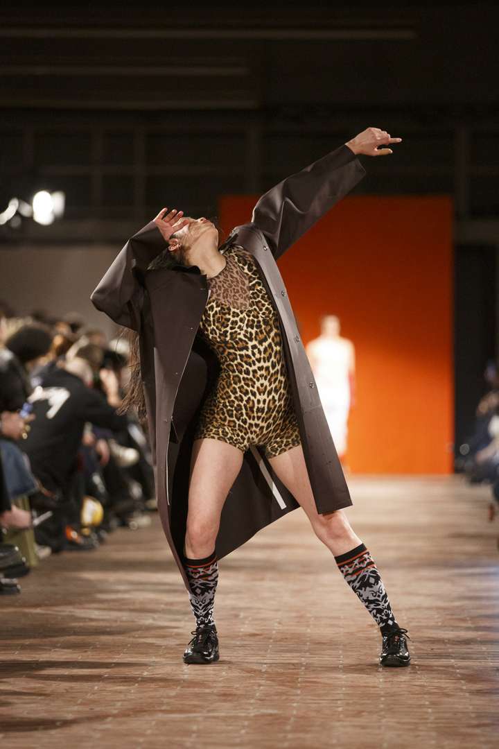 a women dancing on the runway, wearing mid high black happy socks with tattoo pattern