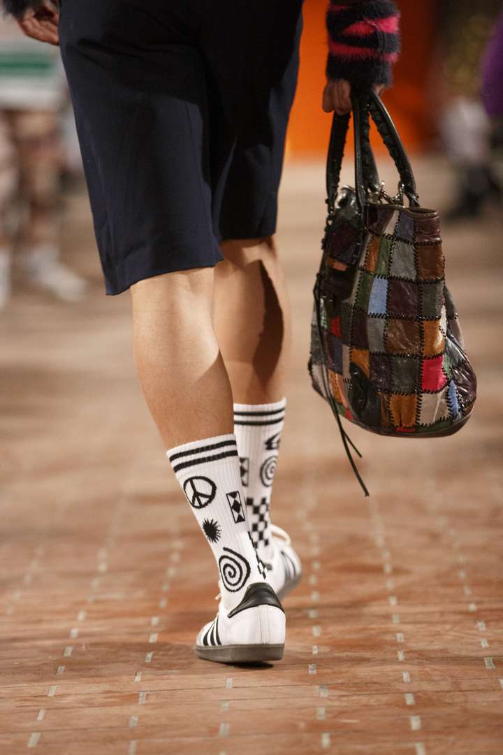 a person walking the runway wearing white and black sneaker socks from happy socks 