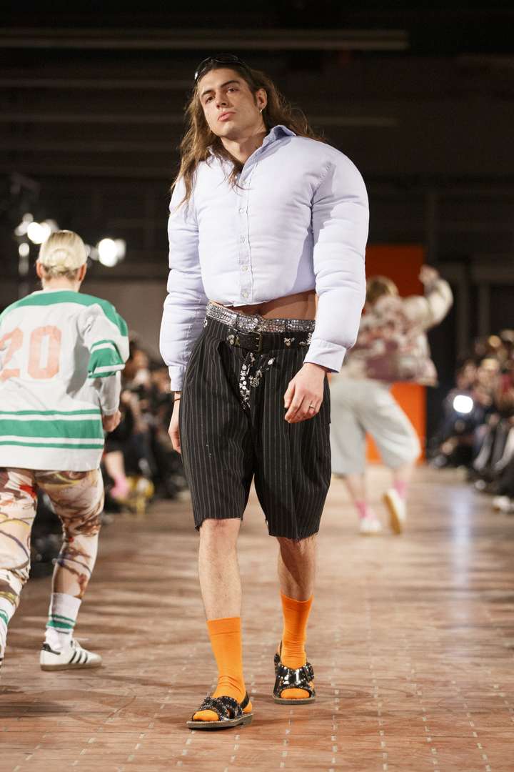 a person walking the runway wearing orange happy socks