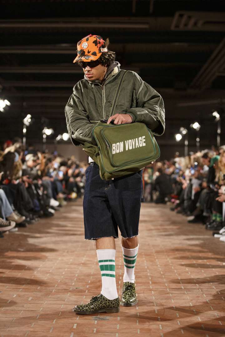 a person walking on the runway, wearing white and green sneaker socks 