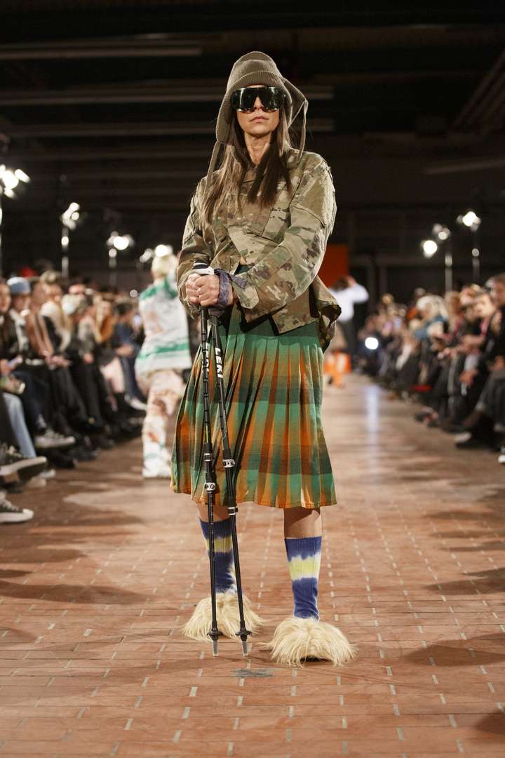 a person posing on the runway, wearing tie dye happy socks