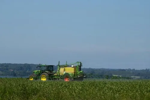 A tractor firing pesticides onto its fields