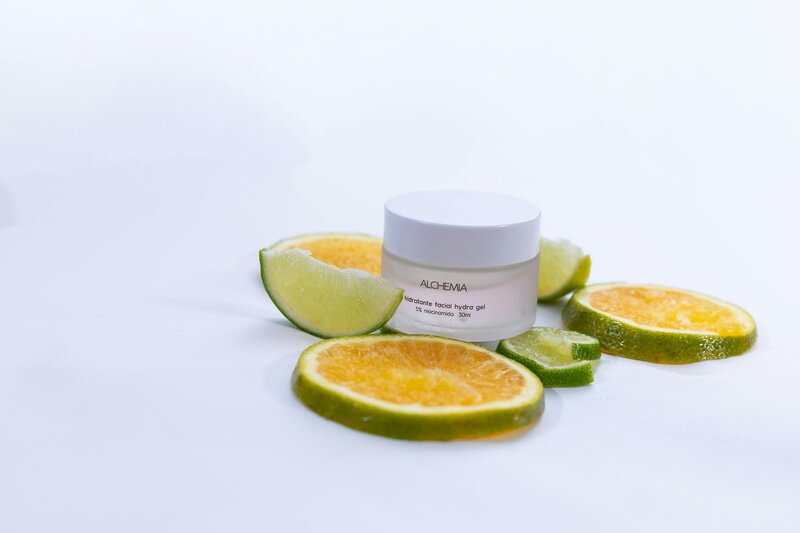 A lightweight facial gel cream jar surrounded by fresh citrus slices on a clean white background, highlighting the association between skincare textures, skincare feel, freshness, and food-inspired sensorial appeal for consumer trends.